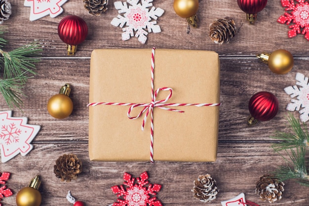 Concetto di composizione di Natale. Top flatlay da vicino sopra guarda la foto dell'arco attuale con diversi accessori di capodanno sulla scrivania marrone