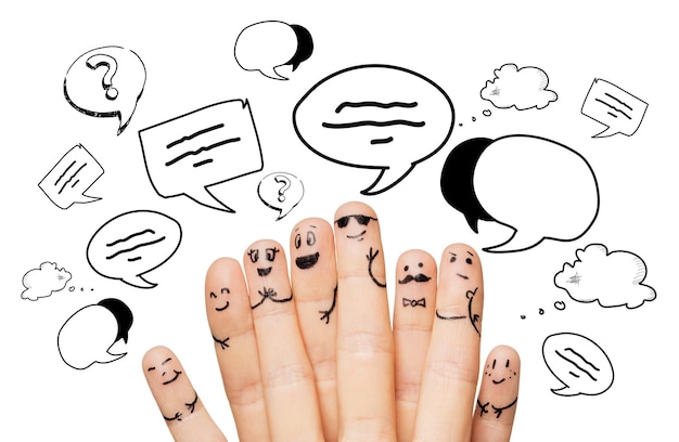 concetto di comunicazione, famiglia, persone e parti del corpo - primo piano di due mani che mostrano le dita con faccine sorridenti sopra le nuvole di testo