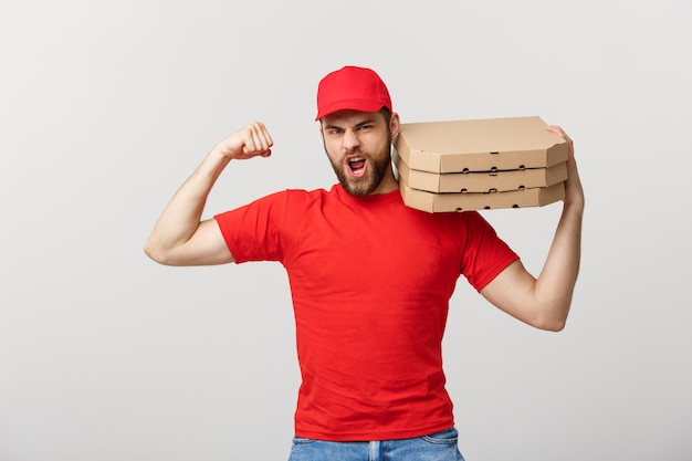 Concetto di consegna - Ritratto di uomo di consegna bello forte flettendo i suoi muscoli e tenendo la scatola della pizza