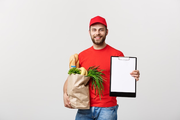 Concetto di consegna: uomo caucasico bello consegna corriere consegna in uniforme rossa con scatola della spesa