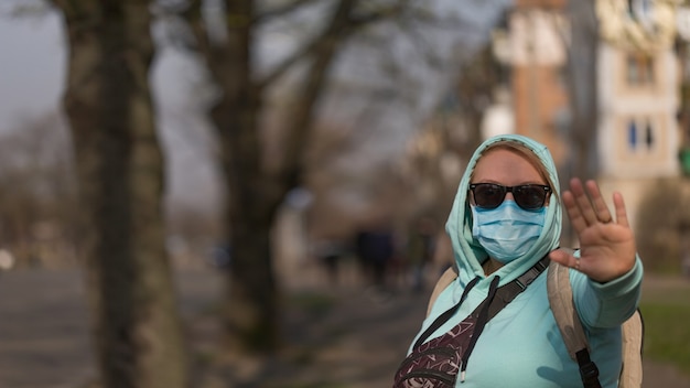 Concetto di coronavirus Chiamata globale per rimanere a casa. Ragazza che indossa una maschera protettiva dalla malattia