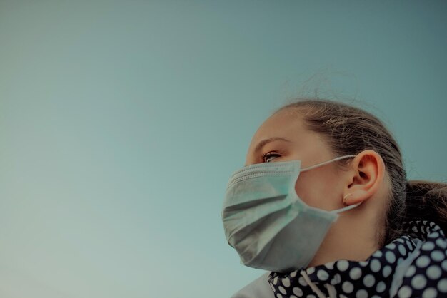 Concetto di coronavirus e inquinamento atmosferico pm2.5.Bambina che indossa una maschera per proteggere pm2.5.Bambina imprigionata a casa per la protezione dal virus corona.Coronavirus di Wuhan e sintomi del virus epidemico.