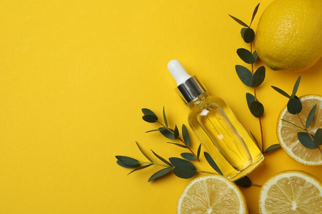 Concetto di cosmetici naturali con olio di limone su sfondo giallo