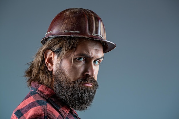 Concetto di costruttore del settore edile Lavoratore uomo barbuto con barba in casco da costruzione o cappello duro Industria dei costruttori di uomini