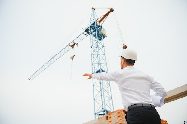 Concetto di costruzione dell'ingegnere che lavora al cantiere con stampa blu