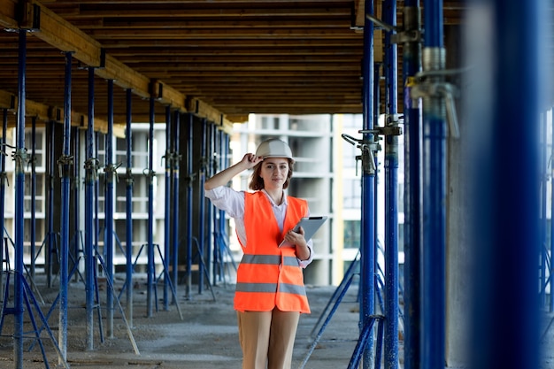 Concetto di costruzione di ingegnere o architetto che lavora al cantiere. Una donna con un tablet in un cantiere edile. Ufficio di architettura.