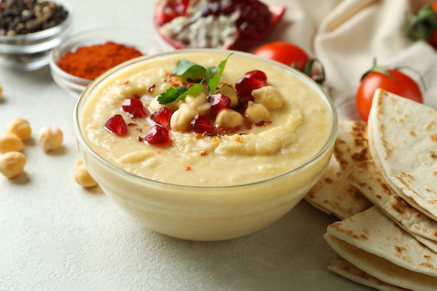 Concetto di cottura dell'hummus sulla superficie strutturata bianca