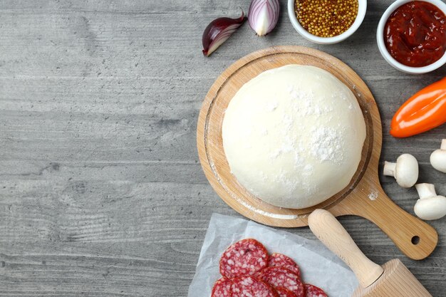 Concetto di cottura della pizza su fondo di legno grigio