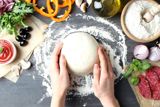 Concetto di cottura della pizza su fondo di legno grigio