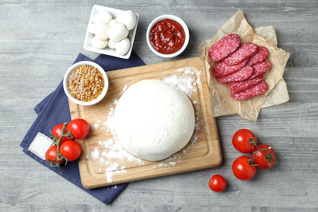 Concetto di cottura della pizza su fondo di legno grigio