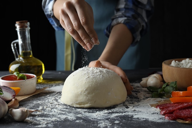 Concetto di cottura della pizza su un tavolo strutturato scuro