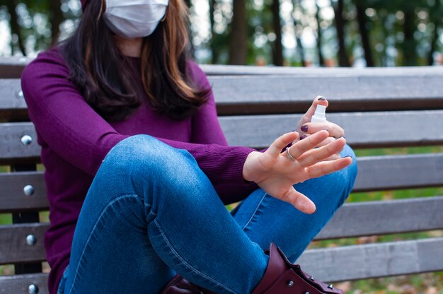 Concetto di COVID-19. Donna che si lava le mani con disinfettante in gel alcolico. Protezione e prevenzione contro il coronavirus.