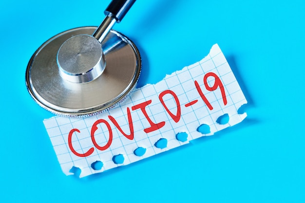 Concetto di COVID-19. Malattia di coronavirus Stetoscopio con scritta COVID-19 su un pezzo di carta. Avvicinamento