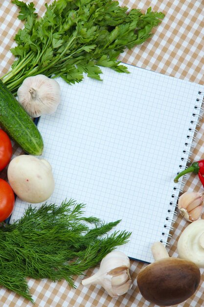 Concetto di cucina Generi alimentari con ricettario vuoto da vicino