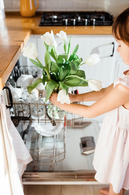 Concetto di cucina pulita Fiori di tulipani bianchi in lavastoviglie