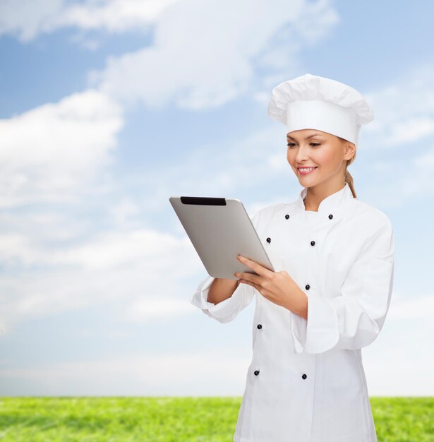 concetto di cucina, tecnologia e cibo - chef femminile sorridente, cuoco o fornaio con computer tablet pc