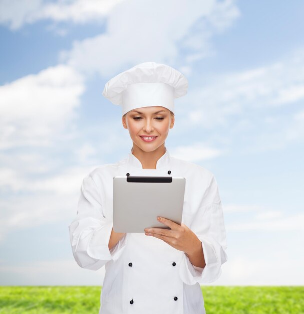 concetto di cucina, tecnologia e cibo - chef femminile sorridente, cuoco o fornaio con computer tablet pc