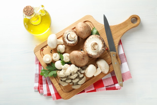 Concetto di cucinare con funghi su legno bianco