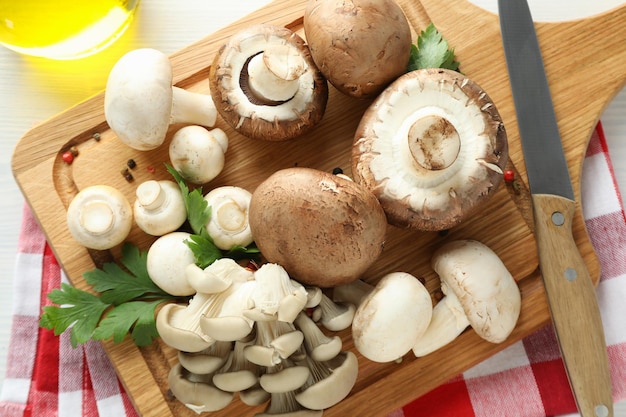 Concetto di cucinare con funghi su legno bianco