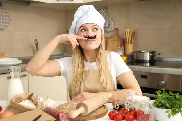 Concetto di cucinare con la giovane donna attraente