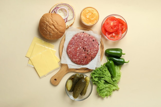 Concetto di cucinare hamburger su sfondo beige