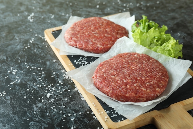 Concetto di cucinare hamburger sul tavolo affumicato nero