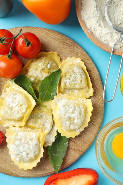 Concetto di cucinare i ravioli su sfondo blu