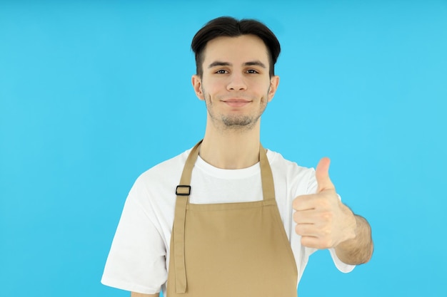 Concetto di cucinare il giovane chef su sfondo blu