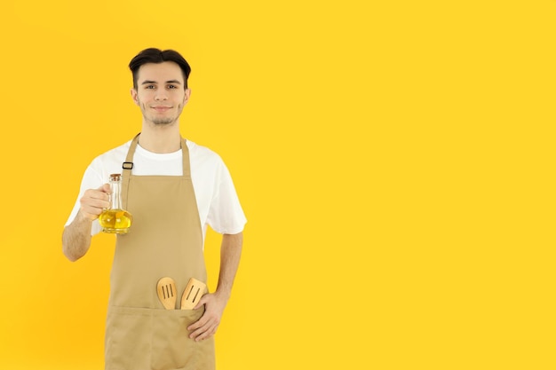 Concetto di cucinare il giovane chef su sfondo giallo