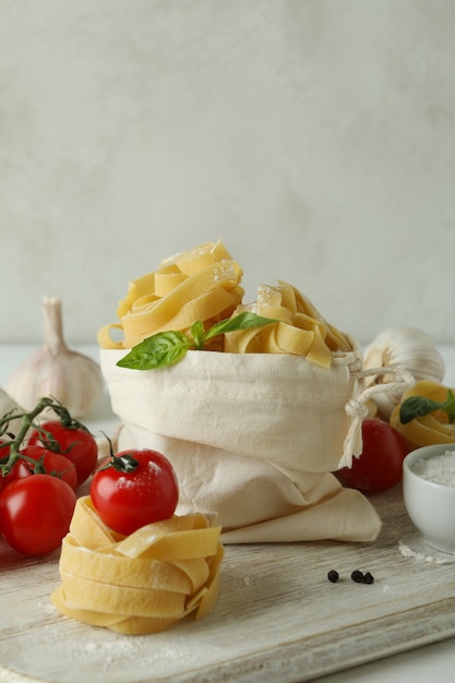 Concetto di cucinare la pasta saporita sulla tavola di legno bianca