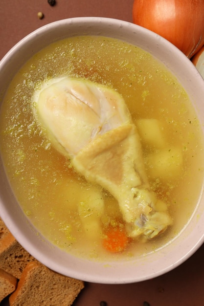 Concetto di cucinare la zuppa di pollo su sfondo marrone