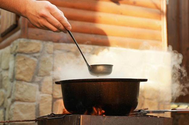 Concetto di cucinare la zuppa sul fuoco