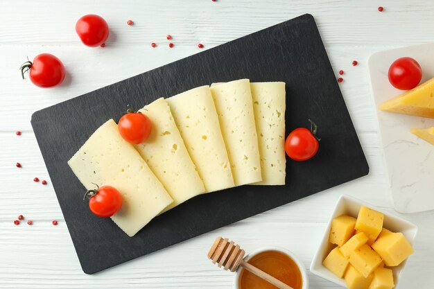 Concetto di cucinare mangiare con formaggio a pasta dura su fondo di legno bianco