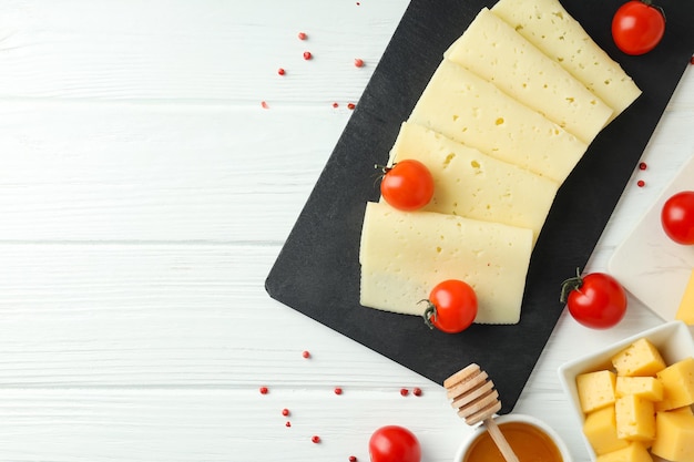 Concetto di cucinare mangiare con formaggio a pasta dura su fondo di legno bianco