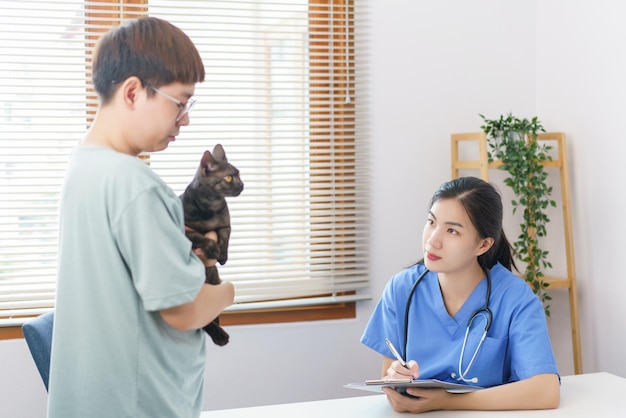 Concetto di cura degli animali domestici Il veterinario femminile sta scrivendo una prescrizione sugli appunti dopo aver esaminato il gatto sanitario