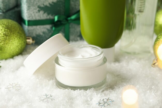 Concetto di cura del viso con cosmetici sullo sfondo con neve decorativa