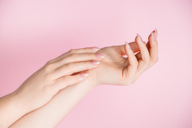 Concetto di cura della pelle Belle mani femminili su sfondo rosa Posto per il testo