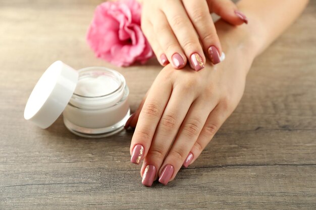 Concetto di cura delle mani con cosmetici su fondo in legno