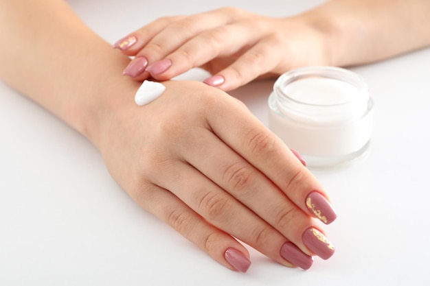 Concetto di cura delle mani con cosmetici su sfondo bianco