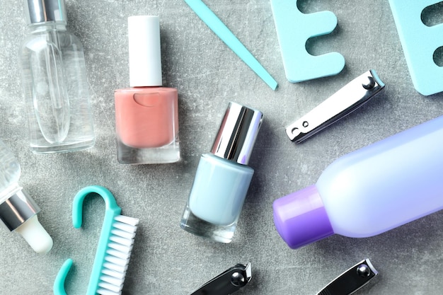 Concetto di cura delle unghie con accessori per manicure su sfondo grigio strutturato