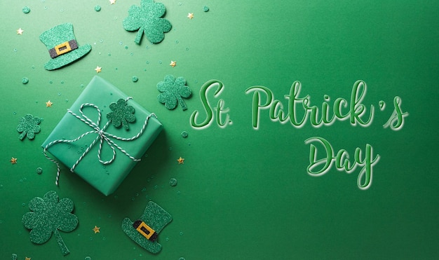 Concetto di decorazione felice per il giorno di San Patrizio realizzato con confezione regalo di foglie di trifoglio trifogli e cappello leprechaun su sfondo verde