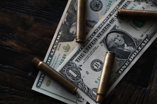 Concetto di denaro criminale di vendita illegale Dollari USA e proiettile per cartucce di pistola su uno sfondo