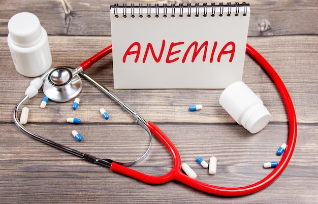 Concetto di diagnosi anemia Foglio con la parola anemia sullo sfondo di pillole e uno stetoscopio Trattamento dell'anemia