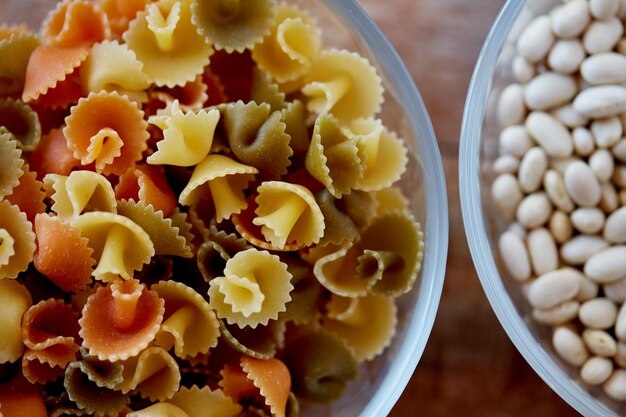 concetto di dieta, cucina, cucina e carboidrati - primo piano di pasta e fagioli in ciotole di vetro sul tavolo