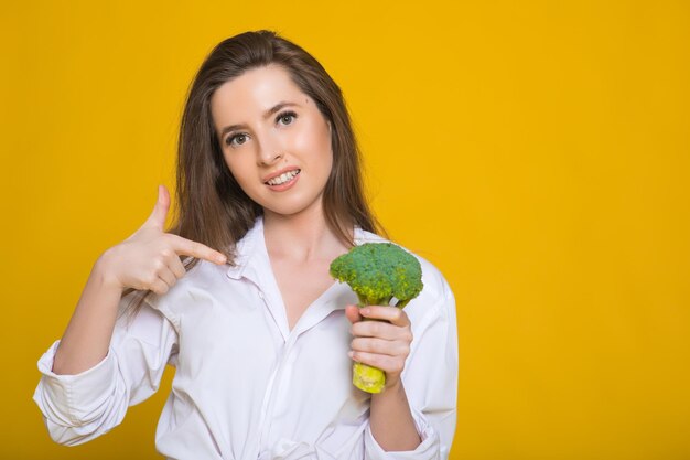 Concetto di dieta disintossicante La donna tiene i germogli di broccoli verdi per un'alimentazione sana