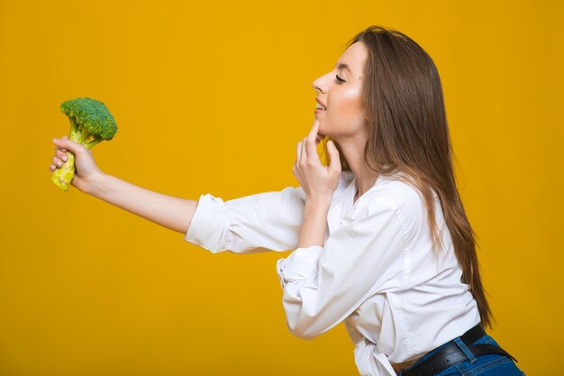 Concetto di dieta disintossicante La donna tiene i germogli di broccoli verdi per un'alimentazione sana