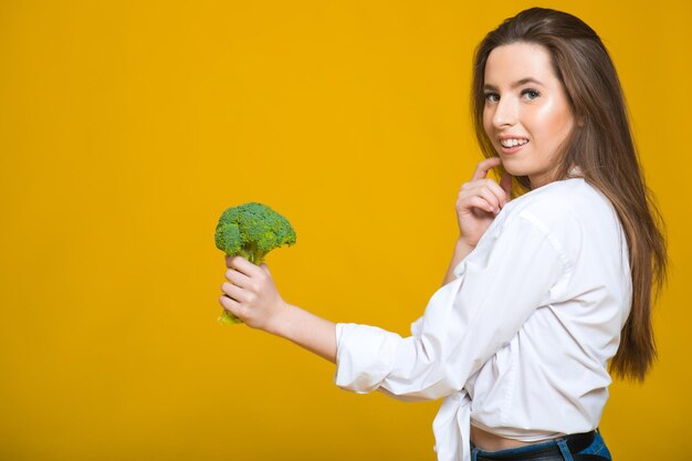 Concetto di dieta disintossicante La donna tiene i germogli di broccoli verdi per un'alimentazione sana