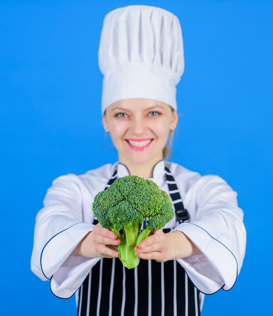 Concetto di dieta Mangiare sano Ragazza indossare cappello e grembiule tenere verdura Razione sana Donna chef professionista tenere verdura broccoli crudi Ricette vegetariane e vegane sane gratuite Cibo crudo sano