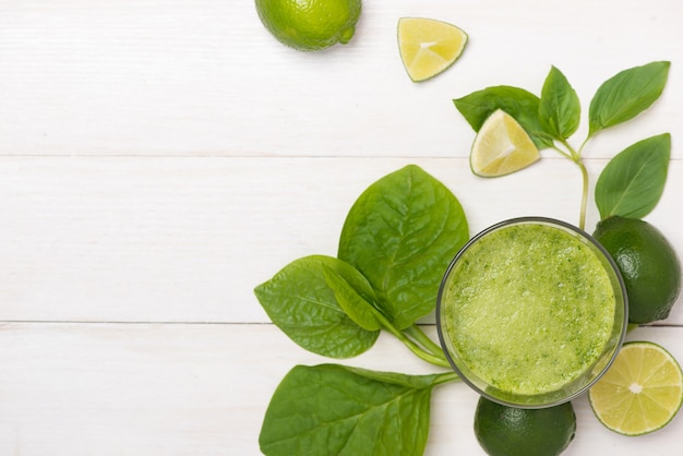 Concetto di disintossicazione. Vaso di vetro di frullato verde bevanda fresca, foglie di spinaci, cetriolo, mela, frutta lime.