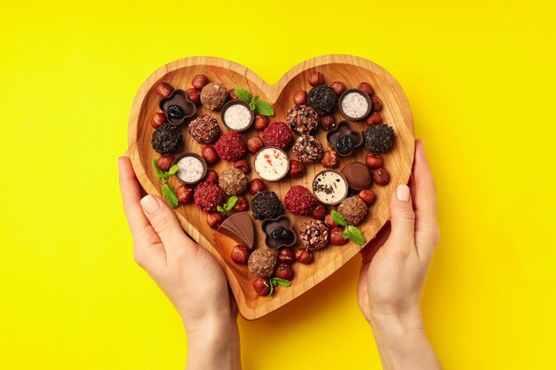 Concetto di dolci con cioccolatini su sfondo giallo